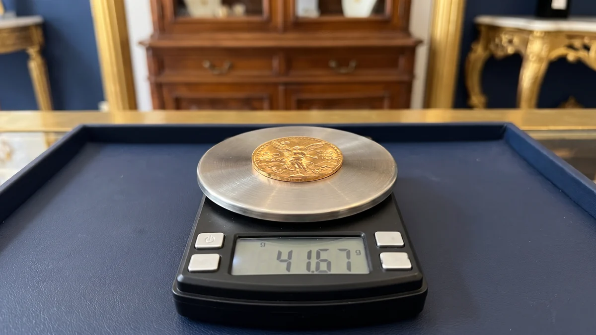 Moneta da 50 pesos messicani in oro su una bilancia di precisione che segna 41,67 grammi